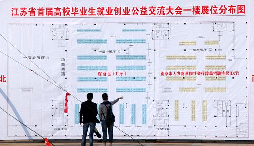 9月24日,在南京国展中心,两名高校毕业生查看主会场展位分布图。当日,江苏省首届高校毕业生就业创业公益交流大会在南京市及其他12个省辖市同时举行,共有5000家单位提供5万个岗位供毕业生选择。在主会场南京国际展览中心,江苏知识产权部门筛选出约50项专利项目和连锁加盟项目供创业的大学生们挑选。交流大会通过企事业单位招聘、大学生创业成果展示、政策咨询和项目洽谈等活动,强化就业创业服务,促进高校毕业生就业和创业。新华社发(王跃武 摄)