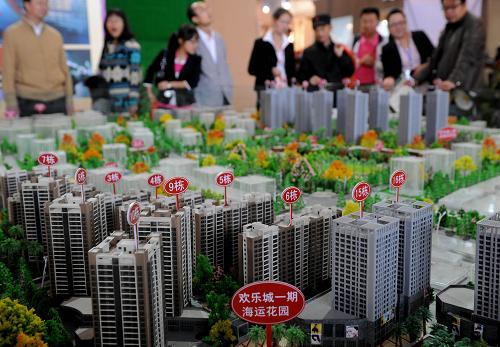 9月24日,一些市民在2011昆明房地产交易会上观看一个新建小区的楼盘模型。9月22日至26日,2011昆明房地产交易会在云南昆明国际会展中心举行。此次房交会共有97家房地产企业参展,销售房源约9万套,展出面积55000平方米,参展数据创下历届昆明房交会之最。然而此次房交会开展以来,看的人多买的人少、消费者和开发商都在观望、楼盘几乎没有优惠、房价仍不见降。据组委会的统计,此次昆明房交会上展出的楼盘价格水平依然处于高位。新华社记者 蔺以光 摄