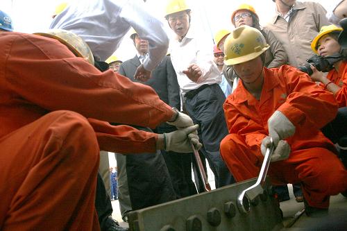 9月28日,在江苏泰州长江大桥施工现场,工人们拧紧最后一颗螺母,大桥顺利合龙。经过4个多月的吊装施工,9月28日,江苏泰州长江大桥钢箱梁全部到位,实现全线合龙,初步形成一个完整的桥面。建设中的泰州长江大桥全长62公里,是世界首座三塔两跨悬索桥,预计2011年年底建成。 新华社发(顾俊 摄)
