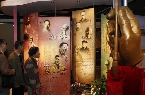 11月21日,观众在展览大厅观看文化名人简介。 当日,茅盾、巴金、夏衍、老舍、冰心、萧乾、季羡林、钱钟书、王元化、梅兰芳、柏杨……99位已故中国文化名人的逾百份珍贵著作手稿,在上海图书馆“中国文化名人手稿展”上向公众展出。一批曾产生过重要影响的文人著作手稿在此次展览中首次亮相,其中包括巴金的《随想录》、夏衍的《懒寻旧梦录》、王元化的《文心雕龙创作论》。展览同时展出了一些名人使用过的毛笔、钢笔等。 新华社记者 任珑 摄