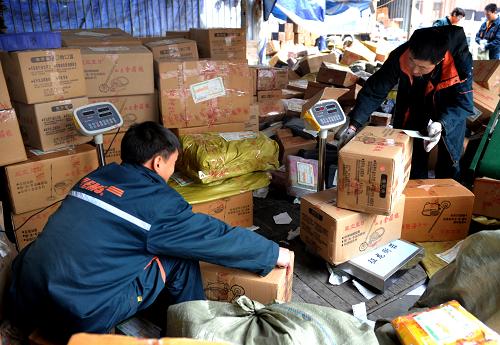 12月29日,义乌一家快递公司的员工忙着揽收、登记包裹。新华社发(张建成 摄)