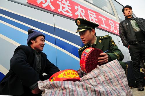 1月15日,“随车警”刘哲劝说一名农民工不要携带鞭炮等易燃易爆物品上车。新华社发(刘国贤 摄)