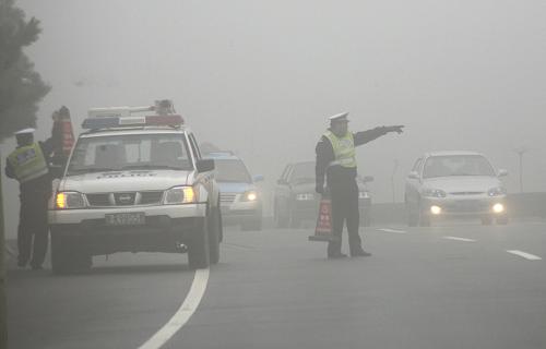 3月17日,在山东201省道威海市机场路上,该市交警五大队民警在浓雾中设置警示标识。当日18时,中央气象台继续发布大雾蓝色预警。预计17日夜间到18日上午,黄淮大部、江淮、江汉、重庆、江南北部、福建南部、广东等地有轻雾,其中局部地区能见度不足500米。新华社发