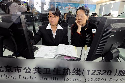 3月20日,一位市民(前右)在北京“12320”卫生热线室里体验卫生热线服务。新华社记者 何俊昌 摄