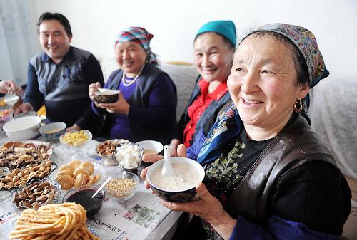 3月21日,在新疆哈巴河县库勒拜乡,哈萨克族妇女库潘(右一)在家中用“纳吾热孜饭”招待客人。当日是“纳吾热孜节”,新疆的哈萨克、柯尔克孜、维吾尔等民族群众吃着用羊肉、小米、麦粒、奶疙瘩等7种食物混合煮成的“纳吾热孜饭”,迎接象征着春回大地、万物复苏的“纳吾热孜节”。新华社记者 沙达提 摄