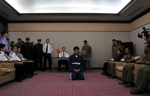 5月10日,在老挝万象的瓦岱国际机场,日前被中老警方联手抓获的湄公河流域“金三角”地区特大武装贩毒集团首犯糯康(前中)被正式依法移交给中国警方,乘中方派出的包机押解到中国。新华社发(塔纳克侬摄)