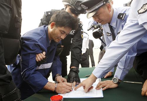 5月10日,在北京首都国际机场,“金三角”特大武装贩毒集团首犯糯康在《逮捕证》上签字。当日,“金三角”特大武装贩毒集团首犯糯康被中国警方从老挝首都万象押解到北京。经中老缅泰四国警方联合工作,现有证据证明,长期盘踞湄公河流域“金三角”地区的武装贩毒集团首犯糯康及其骨干成员与泰国个别不法军人勾结策划、分工实施了“10·5”案件(湄公河惨案)。新华社发(万象 摄)