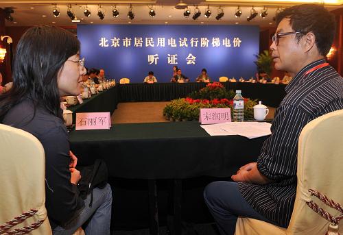 5月11日,消费者代表石丽军(左)与宋润明在听证会前交流。新华社记者 公磊 摄