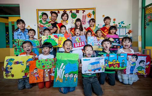 5月31日,法律志愿者与幼儿园小朋友展示创作好的法制儿童画。 当日,天津市北辰区小淀镇法律志愿者来到小淀镇第一中心幼儿园,以“迎六一、讲法制、促和谐”为主题,和幼儿园小朋友一起创作法制儿童画,迎接六一儿童节。 新华社发(张超群 摄)