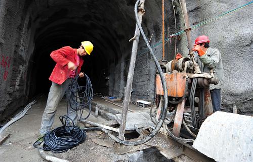 6月8日,两名工人正在贵阳市鱼洞峡水库工程工地上施工。新华社记者 杨楹 摄