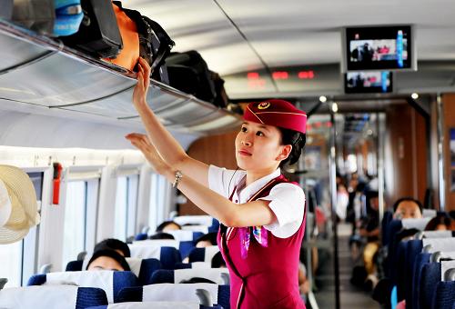 6月30日,乘务员在一列由天津西始发的高铁列车上整理旅客行李。新华社发(杨宝森 摄)