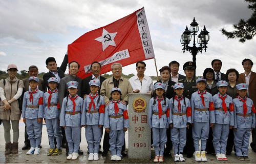 9月28日,到场嘉宾与红军小学的学生代表在中国边境界碑前合影留念。新华社发(万象 摄)