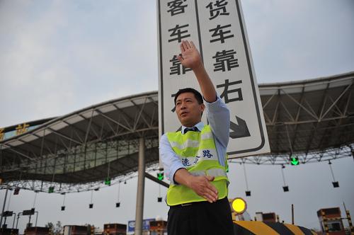 9月28日,江西高速集团的工作人员正在演练分流指挥,工作人员身后是临时分流标志牌。新华社记者 周密 摄