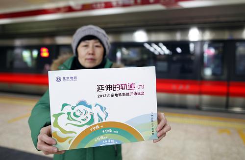 12月30日,一名女士在展示购买的北京地铁新线开通纪念票册。当日,北京地铁新线开通纪念票册在北京发行。该纪念票册共包括两张开通纪念车票和四枚开通纪念封。两张车票以6号线的新型列车和北海白塔为主题设计;纪念封四枚以6号线一期、8号线二期南段、9号线北段、10号线二期四条新线各具特色的车站内景观为主题设计,四枚纪念封上分别贴有新线列车主题个性化邮票一枚,个性化邮票主图为“岁岁平安”,寓意北京地铁年年安全畅行。新华社发(杨乐 摄)