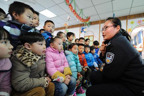 1月10日,合肥市竹荫里派出所民警刘景怡(右一)为孩子们讲解警察肩章的知识。当日,合肥市蜀山区竹荫里社区邀请辖区派出所的两位民警来到西园新村幼儿园,给孩子讲解警徽、臂章、肩章、以及“110”的来历等相关警务知识。活动中,民警还通过现场提问、模拟报警等互动方式,教授小朋友如何报警,提高小朋友的自救意识。新华社记者 杜宇 摄