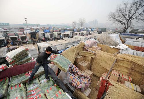 1月10日,一名蔬菜批发商在北京新发地农产品批发市场整理车厢内的蔬菜。新华社记者 罗晓光 摄