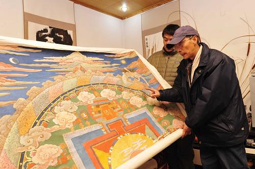 1月19日,西藏美术家协会主席韩书力为新唐卡画作《扎西德勒》提出颜色修改意见。新华社发(刘坤 摄)