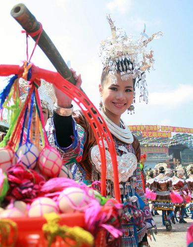 2月22日,在广西融水苗族自治县安太乡林洞村大寨屯,一名苗族姑娘挑着“七色蛋”送给前来“打同年”的客人们。2月20日至22日,广西融水县安太乡林洞村大寨屯举办“打同年”活动,当地数百名苗胞与城里来的“同年”们欢聚一堂,一起开展对歌、芦笙踩堂、文艺晚会等活动,共同迎接新年的到来。据介绍,“打同年”是融水苗族村寨的一种民俗,即友好村寨之间的拜年联欢活动。双方约定,一方向对方发出邀请,另一方则每家派出代表组成“打同年”队伍,由族老带队,吹着芦笙到主方村寨拜年。后来逐渐演化为苗、瑶、侗等少数民族村寨之间联欢的活动,当地俗称“打老庚”,意为交朋友、结兄弟。现在已发展成为多民族的集体交流活动。新华社发(杨保安 摄)