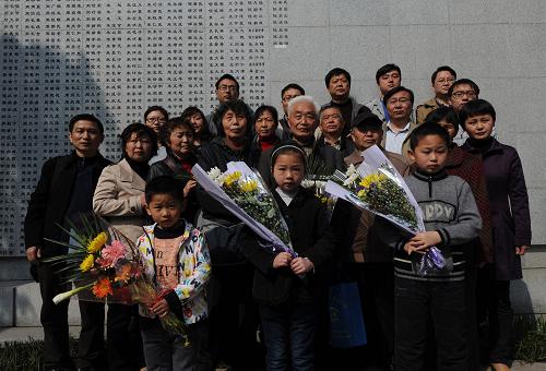 4月4日,阮定东(二排右四)带领一家五代22口人在遇难者名单墙前合影。阮定东的爷爷阮家田的名字最近新刻在遇难者名单墙上。新华社记者 韩瑜庆 摄
