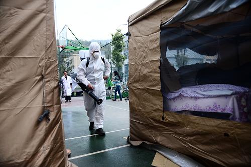4月21日,芦山地震卫生应急前线指挥部疾控卫监组的一名工作人员在芦山县中学受灾群众临时安置点内消毒。新华社记者 张宏祥 摄
