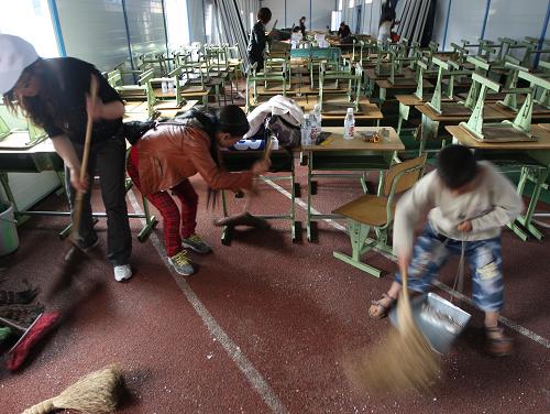 5月1日,雅安天全县第一完全小学的学生、老师、家长齐上阵,清理板房教室内外卫生。新华社发(张晓理 摄)