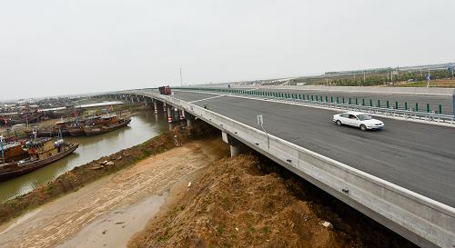 江苏临海高等级公路连云港市赣榆段柘汪河大桥已经建成(5月28日摄)。江苏临海高等级公路是江苏沿海发展战略的重大支撑项目,全长521公里,贯穿连云港、盐城、南通三个沿海省辖市,17个县(市、区),连接沿海18个新区和开发区、10个港区和9个旅游区。工程于2010年6月1日开工,目前已完成投资150多亿元,占总投资80%以上,年内将实现全线基本通车。这条紧邻大海的高等级公路将为江苏沿海开发起到促进作用。新华社记者 杨磊 摄