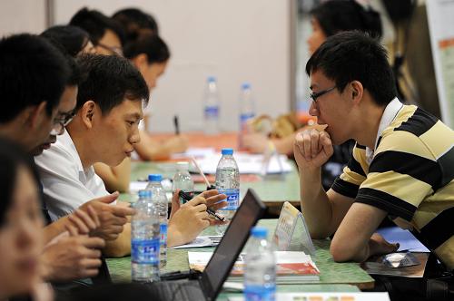6月8日,一位高校毕业生求职者(右)在一家用人单位的摊位前面试求职。当日,2013年浙江省高校毕业生就业招聘大会在杭州和平国际会展中心举行。此次招聘会共有全省1350余家企事业单位参加,面向高校毕业生推出各类就业岗位2.5万余个。新华社记者 鞠焕宗 摄