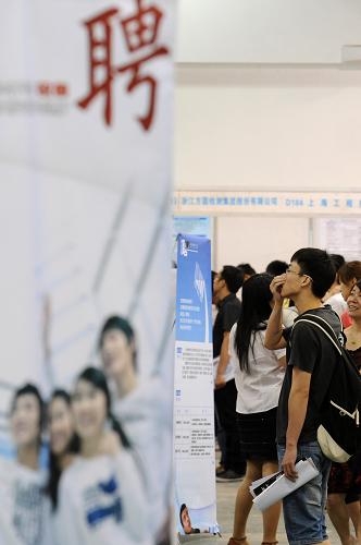 6月8日,一位高校毕业生求职者在招聘会上了解用人单位情况。新华社记者 鞠焕宗 摄