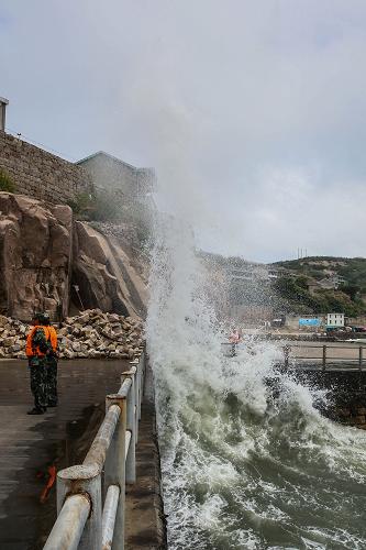 7月12日,在浙江省舟山市东极镇庙子湖岛,海边掀起巨浪。东极边防派出所官兵加强警戒,严防游客接近危险区域。新华社记者 徐昱 摄