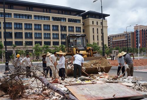 7月19日,工人们在横琴岛澳门大学新校区清运建筑垃圾。新华社记者 魏蒙 摄