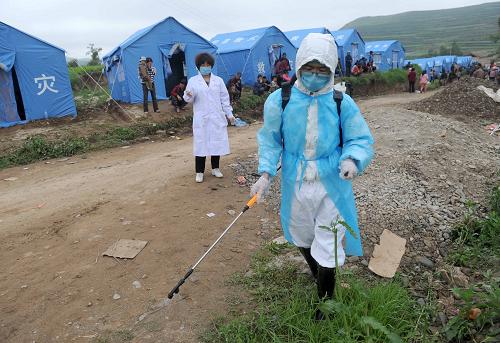 7月23日,在甘肃岷县梅川镇永光村,一名工作人员在受灾群众临时安置点进行消毒防疫。新华社记者 罗晓光 摄