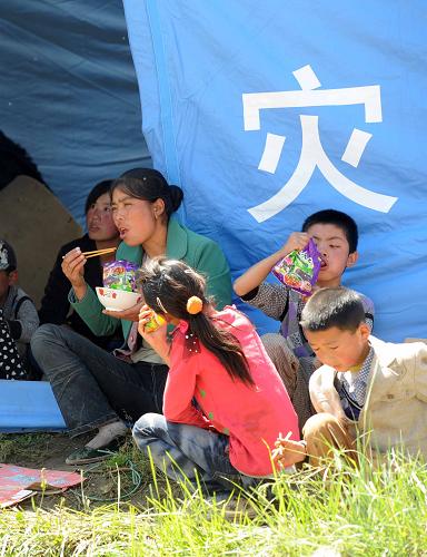 7月23日,在甘肃岷县梅川镇永光村,几位村民在临时安置点吃午饭。新华社记者 罗晓光 摄