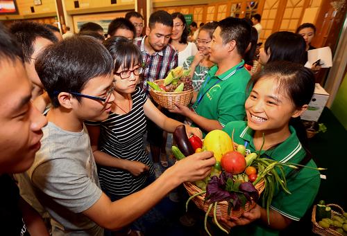 8月9日,在启动仪式上被授予“中国青年高级人才培训基地”的诚誉农庄员工向与会者推介农庄自己种植的有机蔬菜和水果。当日,由中国青年高级人才培训中心主办的“青年科技人才创业就业服务计划”启动仪式在北京举行。据介绍,本次全国青年创业就业服务计划包括培训项目、志愿行动及宣传表彰三阶段内容。第一阶段为建立中国青年高级人才培训基地,主办方将依托诚誉有机农庄进行青年职业生涯规划师培训,并实施农业大学有机示范基地模式复制计划,培养有机农庄管理人才、科技人才及市场营销人才;第二阶段为共青团推动有机农业发展青年志愿行动计划,由全国各地共青团组织推荐优秀团员、青年志愿者参加有机农庄建设和服务工作;第三阶段将开展主题会展和全国性青少年教育系列活动,并与媒体合作开展青年就业创业榜样宣传推广项目。新华社发(董芳忠 摄)