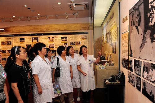 8月16日,北京协和医院妇产科马良坤教授(右一)向学员介绍我国著名妇产科医生林巧稚。新华社记者 何俊昌 摄