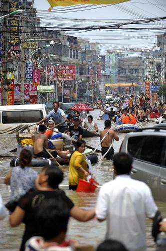 8月20日,在汕头市潮南区陈店镇,街道变水道,当地群众积极开展自救。新华社记者 梁旭 摄
