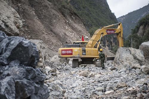 9月5日,武警水电部队挖掘机在清理通往巴拉格宗景区道路上的最后一个塌方点。新华社记者 张可任 摄