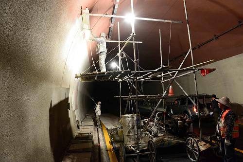 10月18日,建设者在宜巴高速公路石门垭隧道内进行涂装施工。新华社发(邹远景 摄)