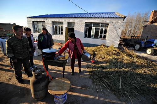 10月31日,在查干花镇腰英吐村,一户村民在院中做饭。新华社记者 张楠 摄