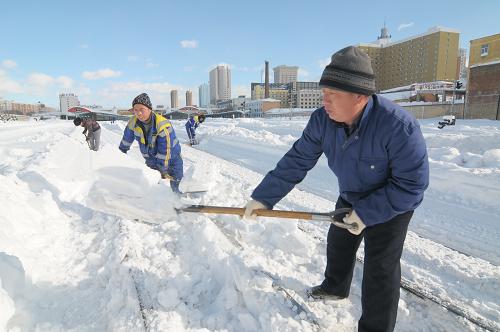 11月26日,牡丹江铁路车站工作人员在清理轨道上的积雪。新华社发(张春祥 摄)