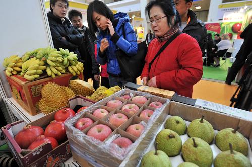 11月28日,观众在展览会上观看来自泰国的水果。新华社发(王京生 摄)