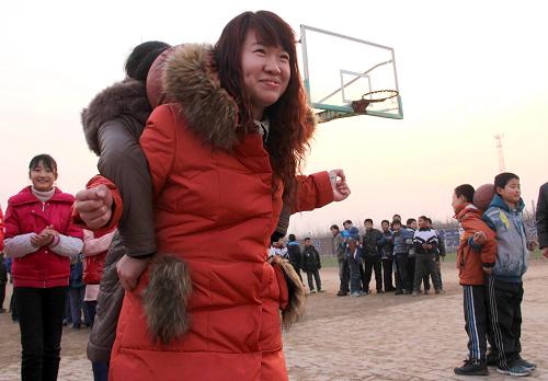 12月4日,特岗教师付丽与学生们在操场上做游戏。