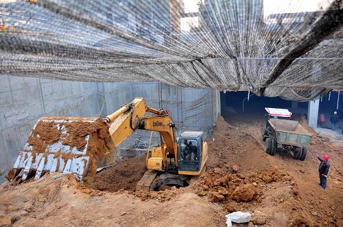 12月2日,建筑工人在河北省邢台市开元观唐项目的建筑工程基槽防尘棚内工作。河北省邢台市扬尘治理第三大队针对土方工程施工扬尘的实际情况,创立“土方工程全封闭防尘施工法”,有效地解决了土方工程作业扬尘的难题,实现了绿色施工。新华社记者 杨世尧 摄