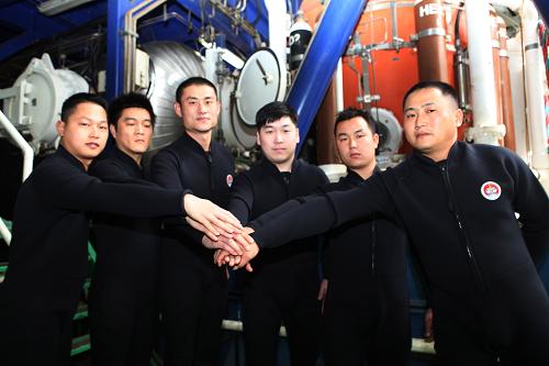 参加中国首次300米饱和潜水作业的6名饱和潜水员在潜水钟前合影(1月9日摄)。新华社发