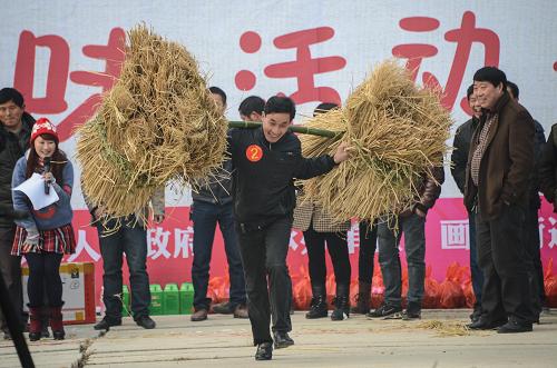1月18日,在浙江省长兴县画溪街道,草莓合作社的农民和游客参加趣味农事活动“挑稻草”。新华社记者 徐昱 摄