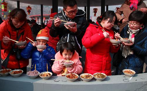 2月15日,人们在北京市怀柔区琉璃庙镇杨树底下村品尝“敛巧饭”。当日,北京市怀柔区琉璃庙镇第九届“敛巧饭民俗风情节”在杨树底下村开幕,吸引了众多游客走进小山村品尝传承百年的“敛巧饭”。北京怀柔杨树底下村“敛巧饭”习俗起源于清代嘉庆、光绪年间,具有鲜明的地域特色。每年的正月十六,杨树底下村的妇女将村中少女到各家敛收的食粮、蔬菜制成“敛巧饭”,供全村人共食。人们欢聚一处,食用“敛巧饭”,其乐融融,期盼吉祥。2008年,“敛巧饭”习俗入选国家级非物质文化遗产名录。新华社发(卜向东 摄)
