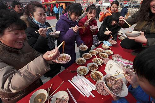2月15日,人们在北京市怀柔区琉璃庙镇杨树底下村品尝“敛巧饭”。新华社发(卜向东 摄)
