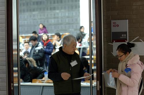 1月15日,在北京大学考点内,监考老师在核对考生信息。 当日,2011年全国硕士研究生入学考试开考。据悉,2011年全国硕士研究生报考人数达151万人,比上年增长11万人,创下2001年以来的最高纪录。 新华社记者 赵琬微 摄