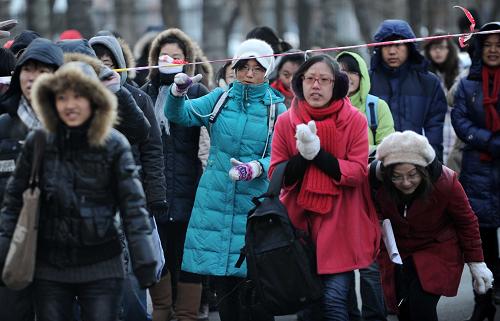 1月15日,考生钻过天津工业大学考场外的警戒线步入考场。 当日,2011年全国硕士研究生入学考试开考。据悉,2011年全国硕士研究生报考人数达151万人,比上年增长11万人,创下2001年以来的最高纪录。 新华社记者岳月伟摄