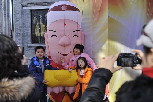 2月17日,几名小朋友在北京前门大街的一处充气人偶前留影。新华社记者 鲁鹏 摄