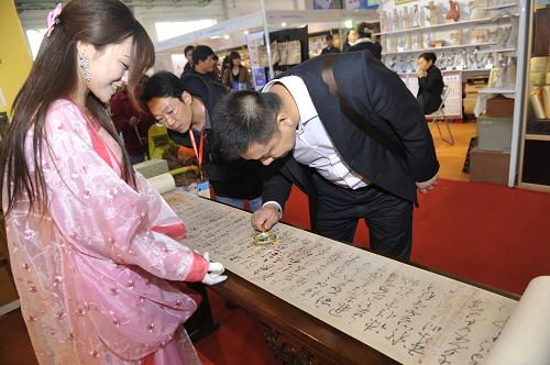 3月16日,一名观众在用放大镜欣赏《怀素自叙帖》高仿精品。新华社记者 鲁鹏 摄